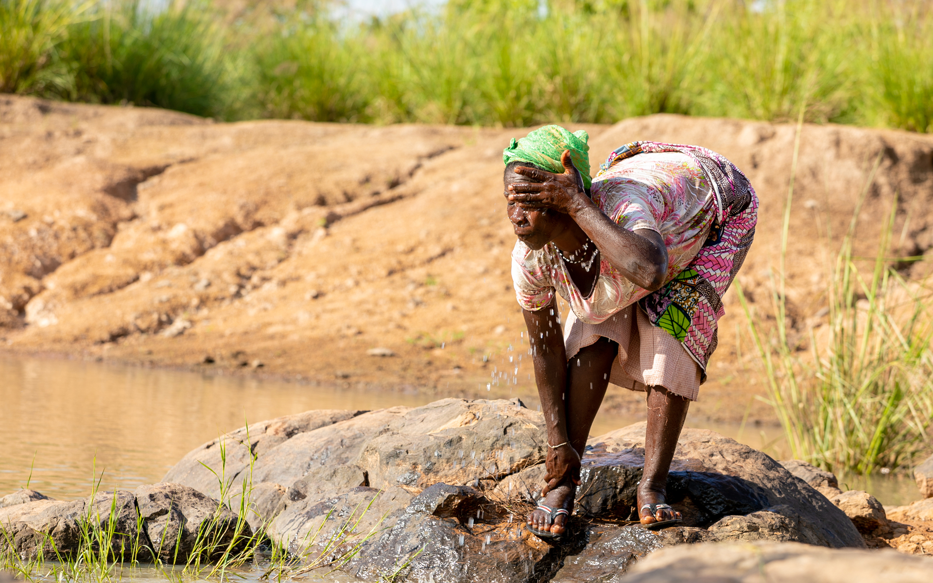 A women washing her face in the Daka river in Ghana.