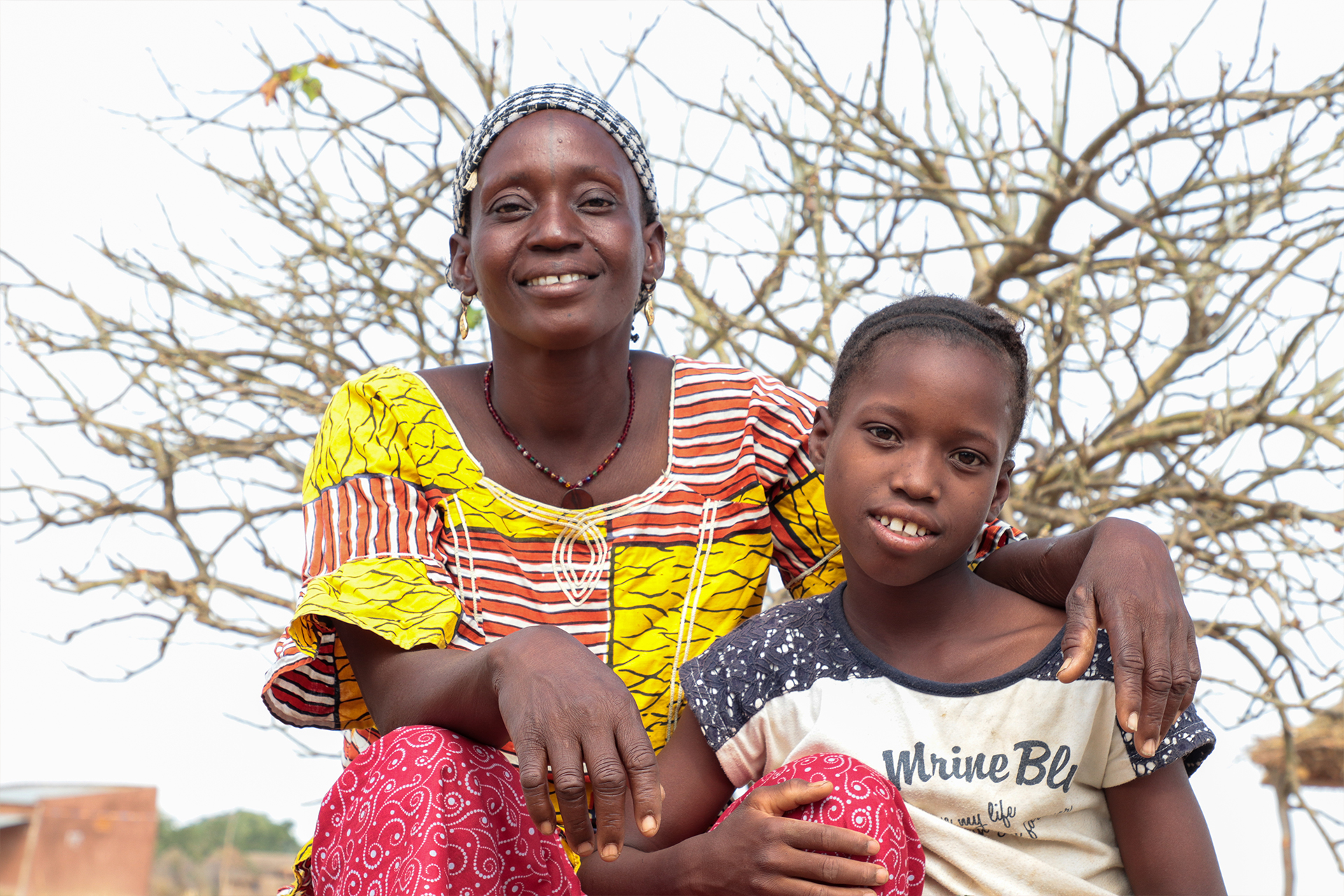 Djamako, a woman on Tree Aid's She Grows project, smiling with her daughter.