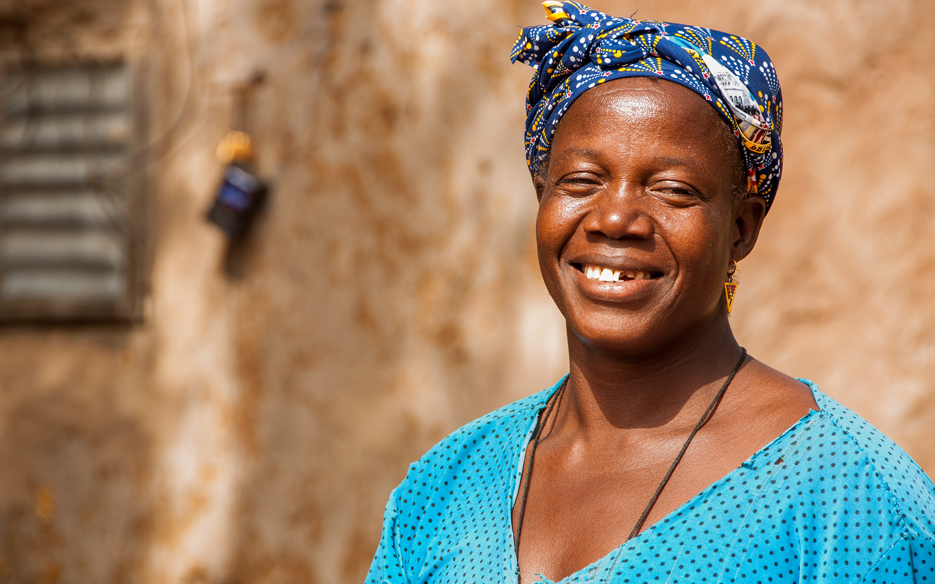 Bernadette, a women in Mali, smiling in her home.