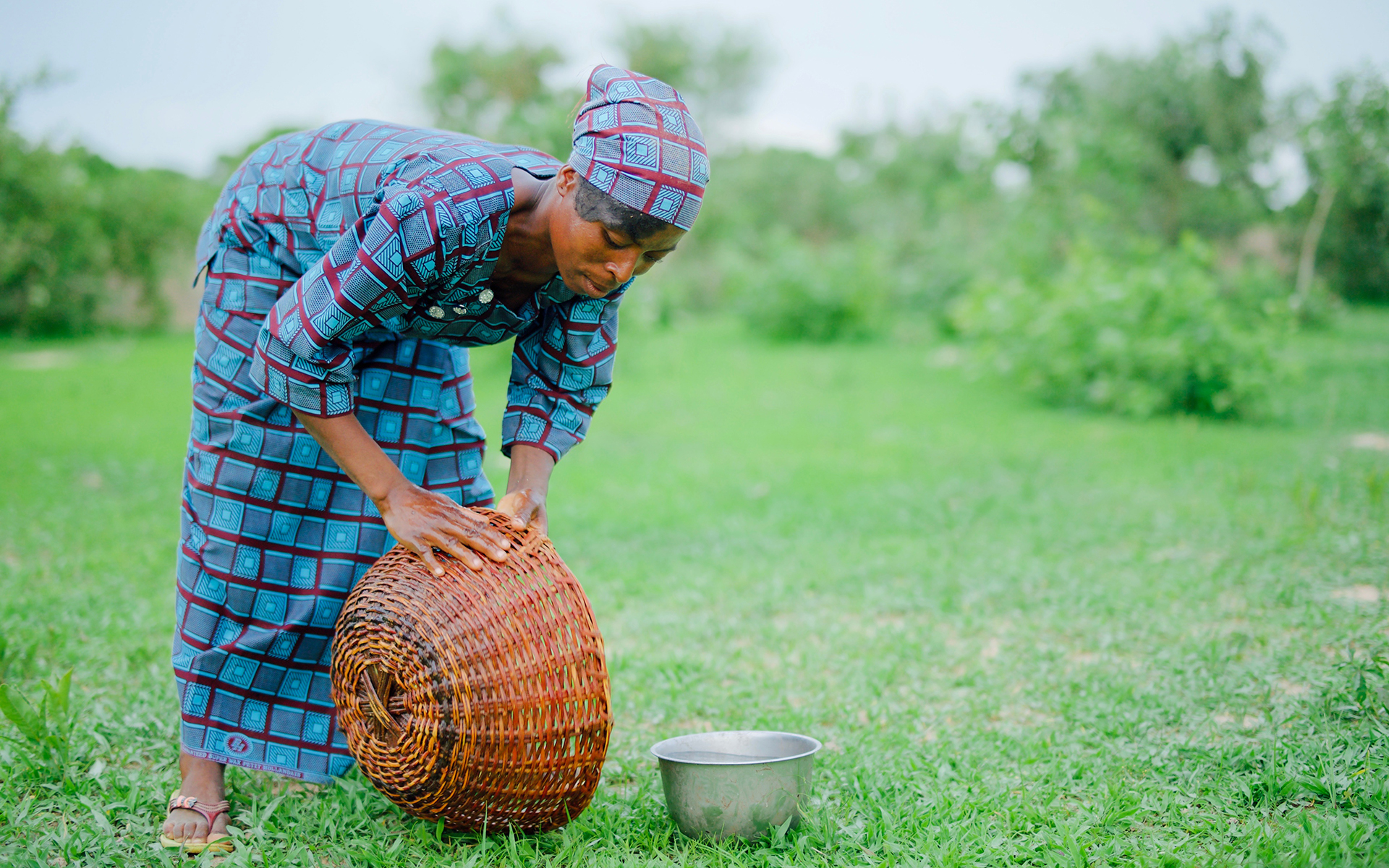 Kapouri, a member of a shea butter enterprise group in Burkina Faso, washing bowls used to collect shea nuts.