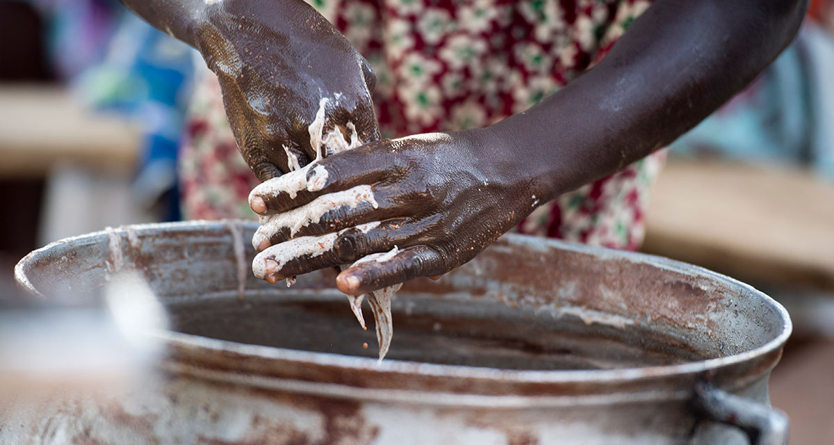 A Women In Nakolo Union, Ghana, uses her hands to churn Shea Butter Which Is Commonly Used In Cosmetics. Photo Rowan Griffiths, Daily Mirror.