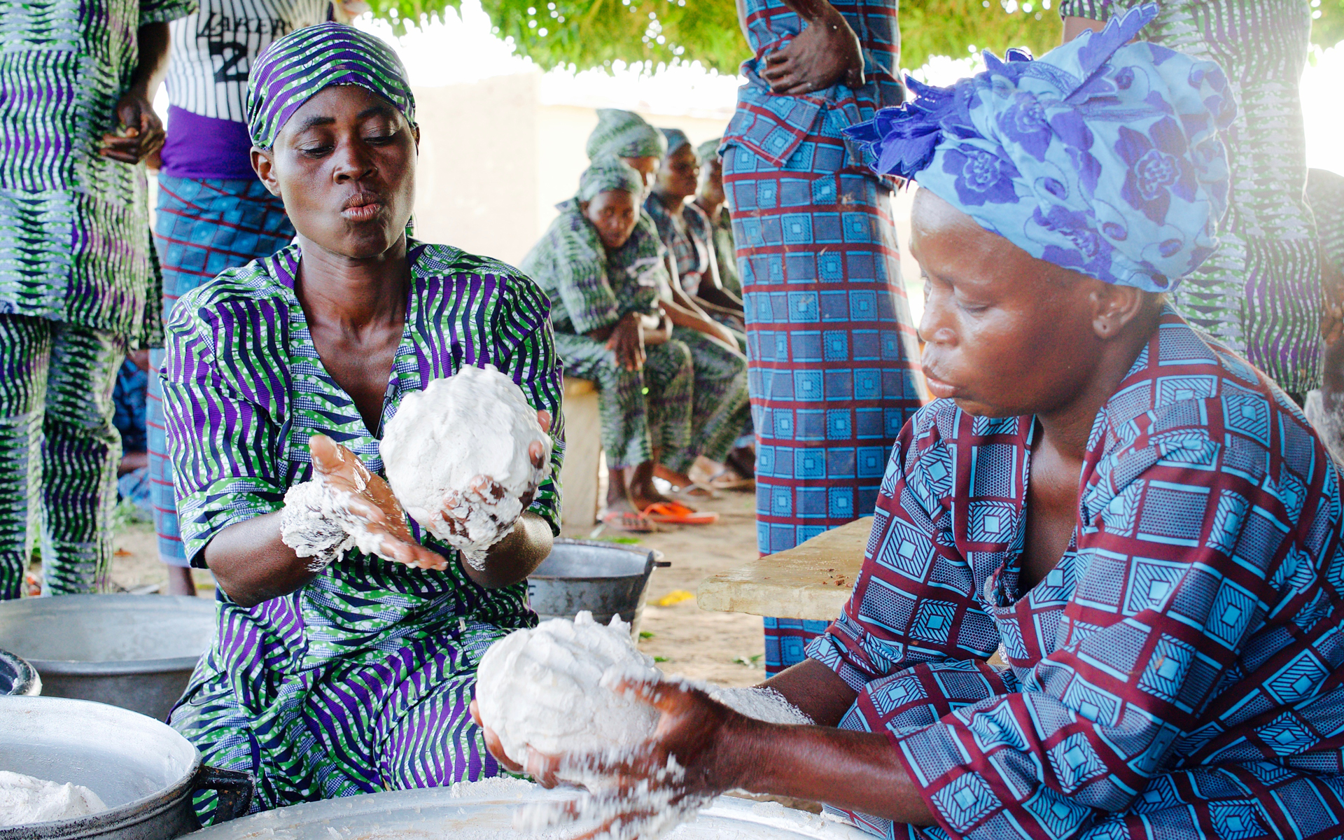 Two members of a women's shea butter enterprise group are making shea butter.