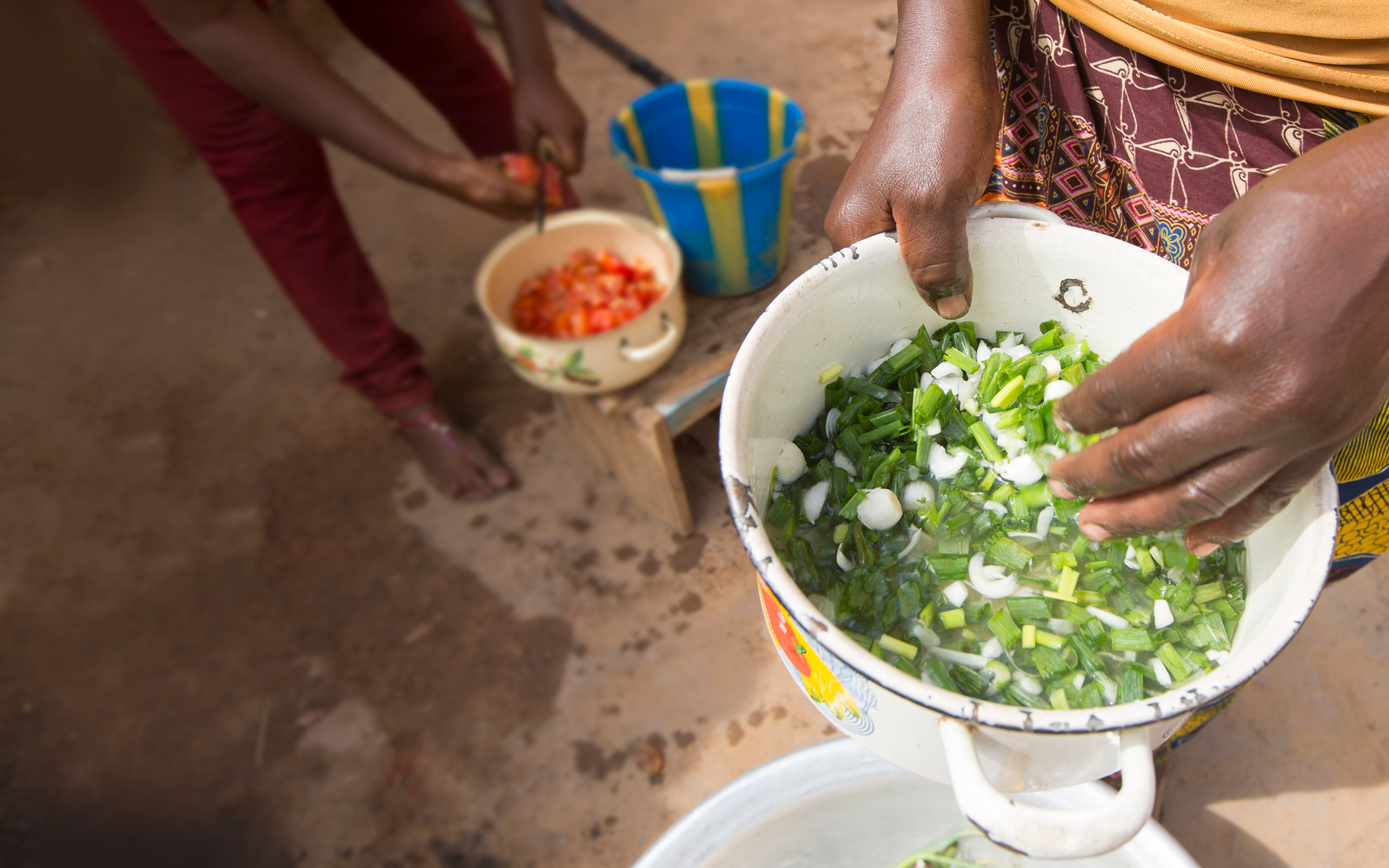 Close up of moringa leaves in a bowl being cooked up to feed a family.