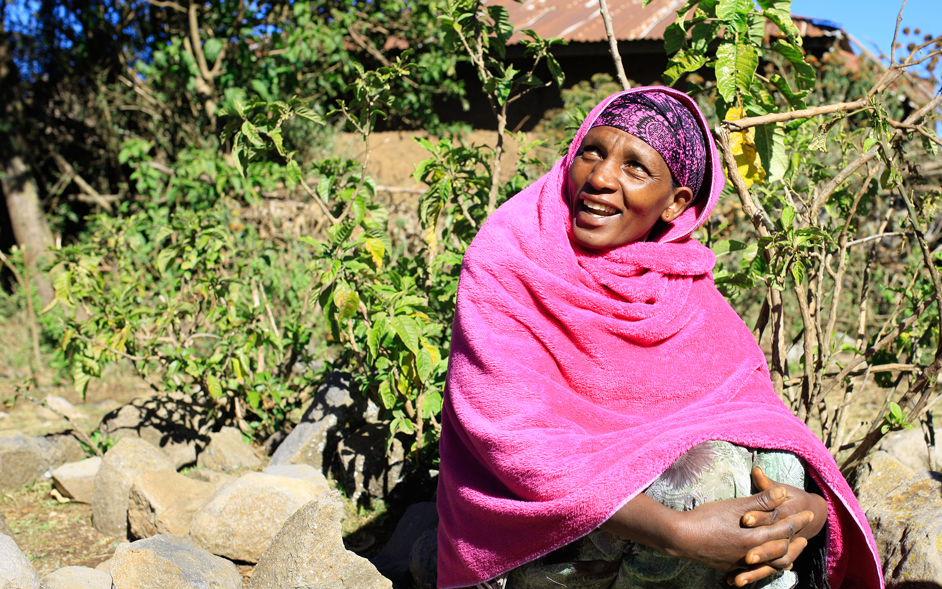A women in bright pink clothes smiling.