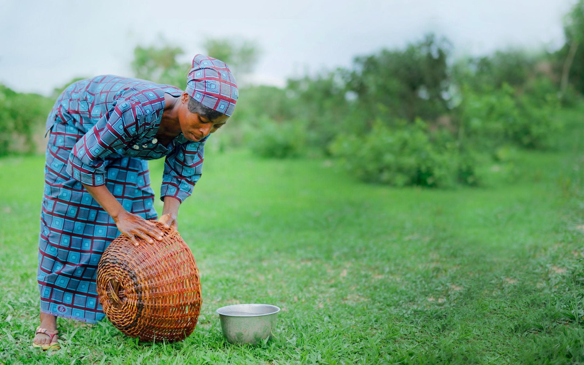 Kapouri, a woman in Burkina Faso, washing out a bowl used to collect shea nuts.