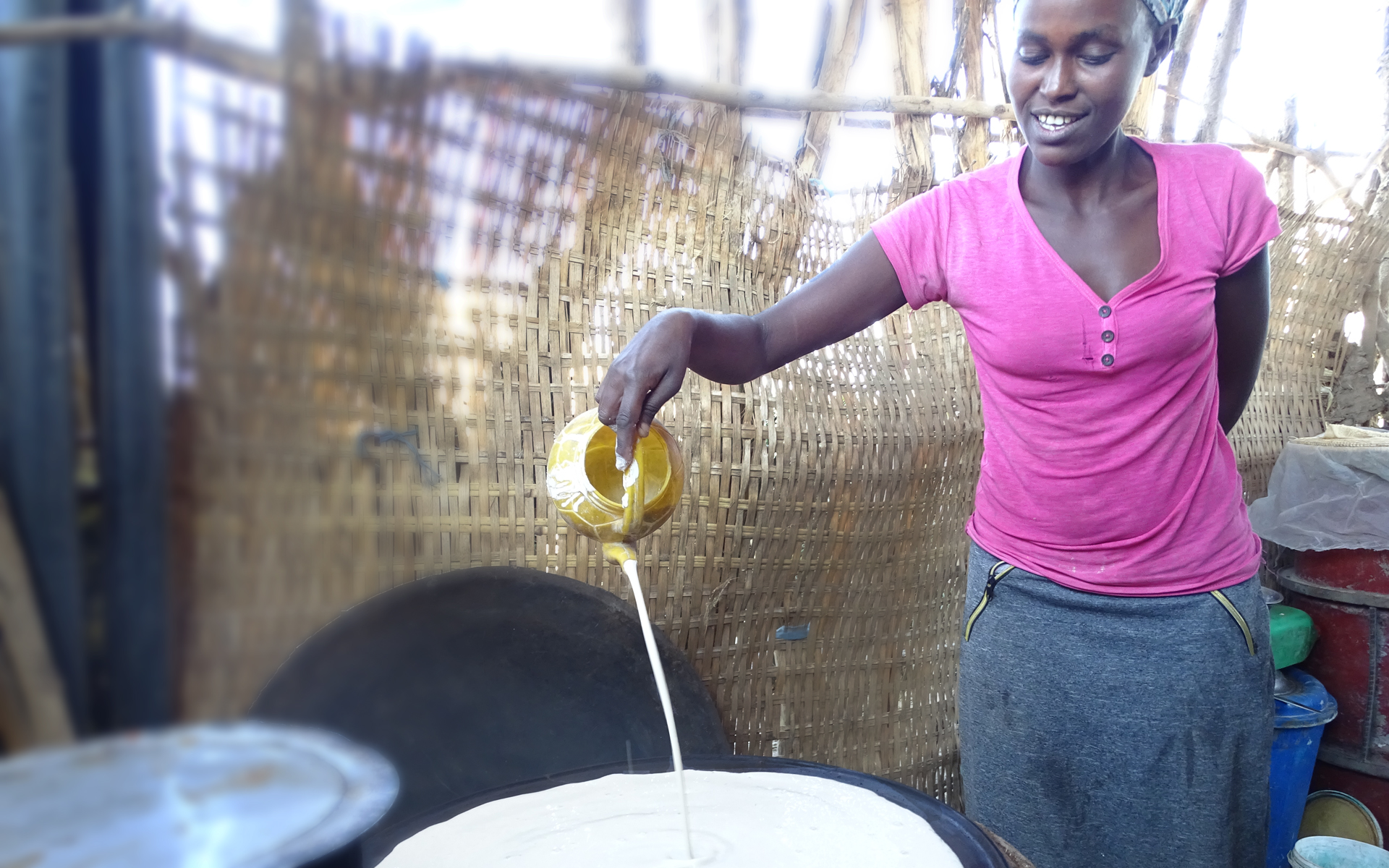 A woman in Ethiopia cooking injera on a fuel-saving stove that she received through a Tree Aid project.
