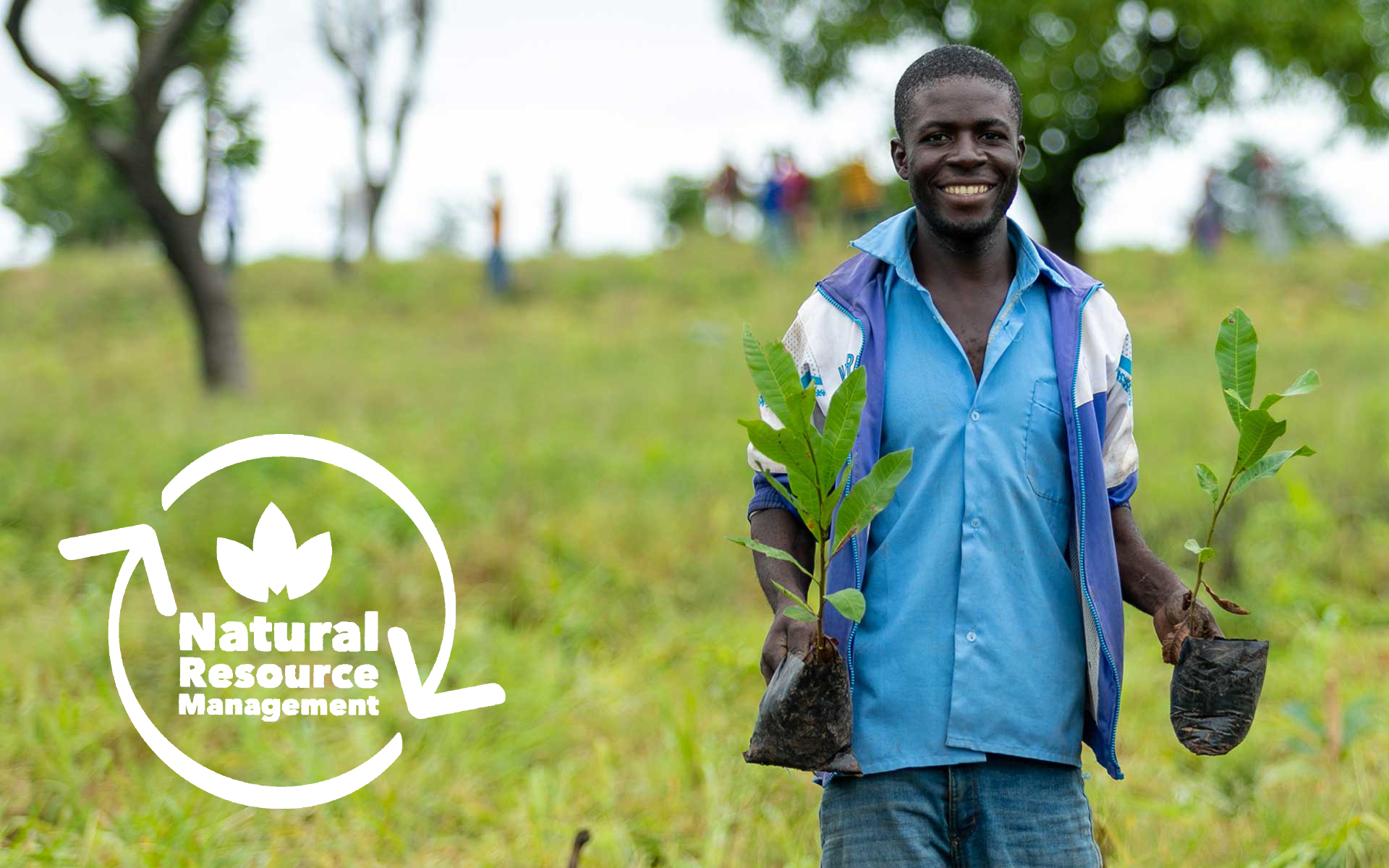 Francis, a man we are working with in Ghana, holding a tree sapling in each hand which he will plant in the community. 